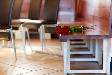 Image showing red roses on bench at funeral in church