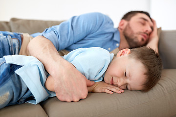 Image showing happy father and son sleeping on sofa at home