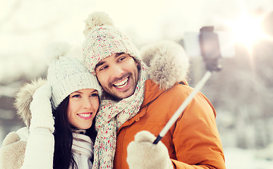 Image showing happy couple taking selfie by smartphone in winter