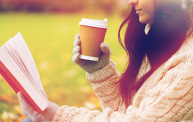 Image showing woman with book drinking coffee in autumn park