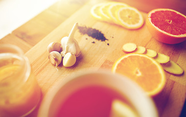 Image showing ginger tea with honey, citrus and garlic on wood