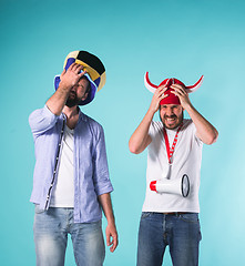 Image showing The two football fans over blue