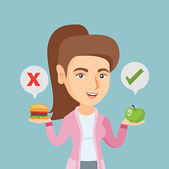 Image showing Woman choosing between hamburger and cupcake.