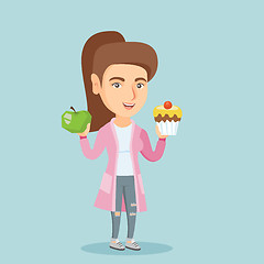 Image showing Caucasian woman choosing between apple and cupcake