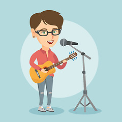 Image showing Woman singing into a mic and playing the guitar.