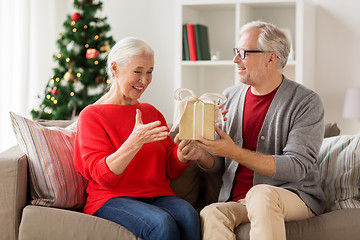 Image showing happy smiling senior couple with christmas gift