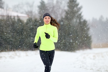 Image showing happy woman running outdoors in winter