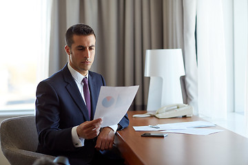 Image showing businessman with papers working at hotel room