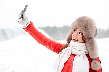 Image showing happy woman taking selfie outdoors in winter