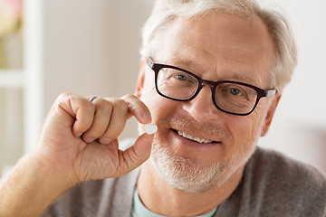 Image showing happy senior man with heart shaped pill