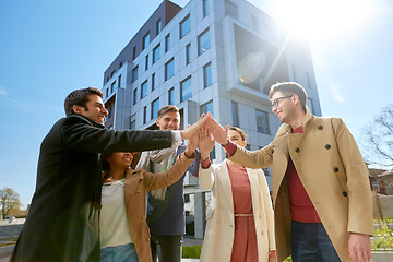 Image showing group of happy people making high five in city