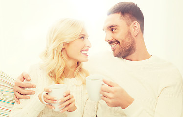 Image showing happy couple with cups drinking tea at home