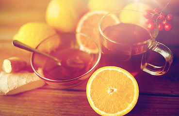 Image showing tea with honey, orange and rowanberry on wood