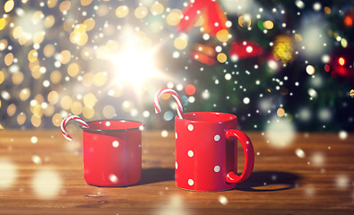 Image showing christmas candy canes and cups on wooden table