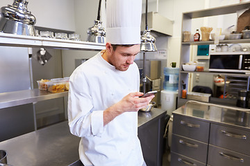 Image showing chef cook with smartphone at restaurant kitchen