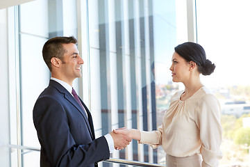 Image showing smiling business people shaking hands at office