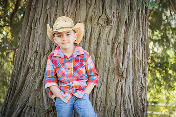 Image showing Mixed Race Young Boy Wearing Cowboy Hat Standing Outdoors.