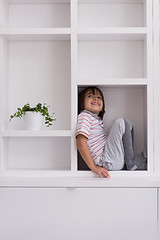 Image showing young boy posing on a shelf