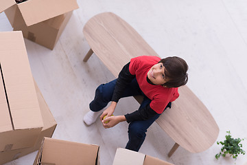 Image showing boy sitting on the table with cardboard boxes around him top vie