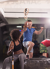 Image showing multiethnic couple after workout with hammer