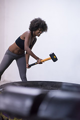 Image showing black woman workout with hammer and tractor tire