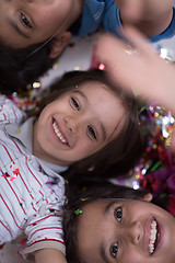 Image showing kids  blowing confetti while lying on the floor