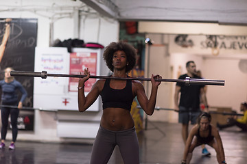 Image showing black woman lifting empty bar