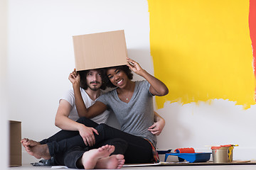 Image showing young multiethnic couple playing with cardboard boxes