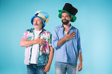 Image showing The two football fans singing the national anthem over blue