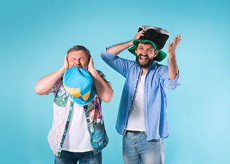 Image showing The two football fans singing the national anthem over blue