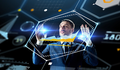 Image showing businessman working with charts on virtual screen