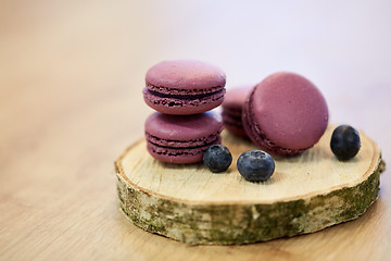 Image showing blueberry macarons on wooden stand