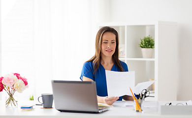 Image showing happy woman with papers and laptop at office