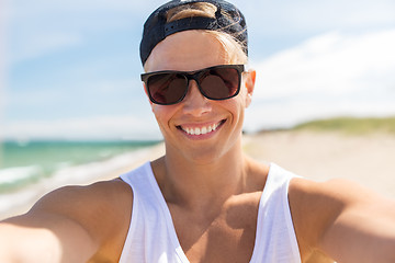 Image showing man in sunglasses taking selfie on summer beach