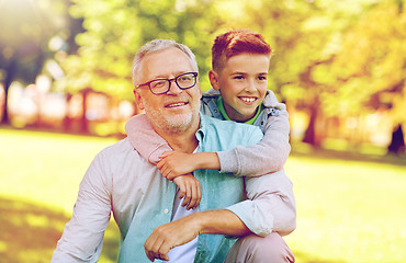 Image showing grandfather and grandson hugging at summer park