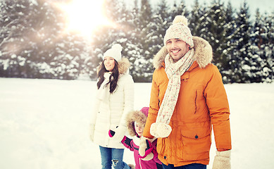 Image showing happy family in winter clothes walking outdoors