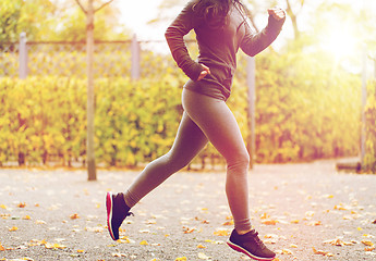 Image showing close up of young woman running in autumn park