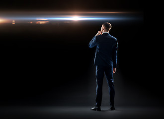 Image showing businessman over black looking at laser light