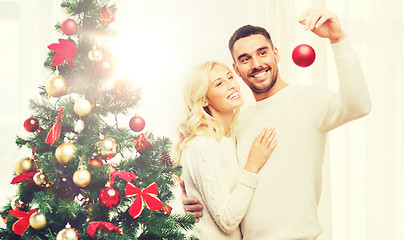 Image showing happy couple decorating christmas tree at home