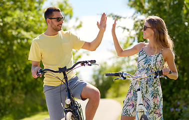 Image showing happy couple with bicycles making high five