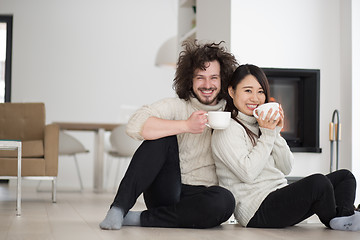 Image showing happy multiethnic couple  in front of fireplace