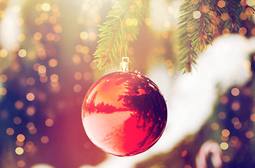 Image showing red christmas ball on fir tree branch with snow