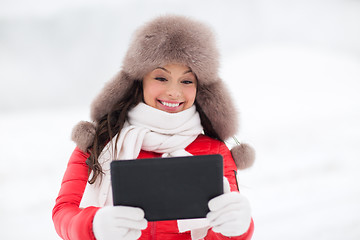 Image showing woman in winter fur hat with tablet pc outdoors