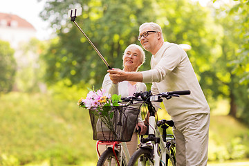 Image showing senior couple with bicycles taking selfie at park