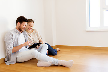 Image showing happy couple with tablet pc computer at new home