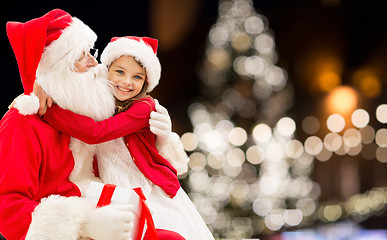 Image showing santa claus with happy girl over christmas tree