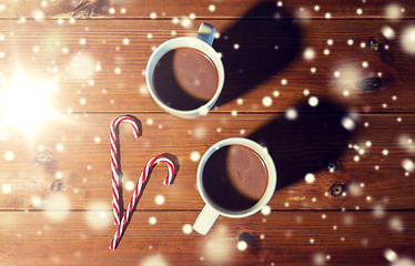 Image showing christmas candy canes and cups on wooden table