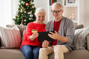 Image showing happy senior couple with tablet pc at christmas