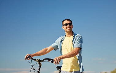 Image showing happy smiling man with bicycle outdoors