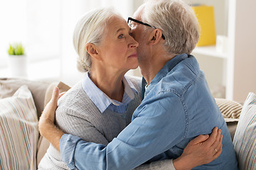 Image showing sad senior couple hugging at home